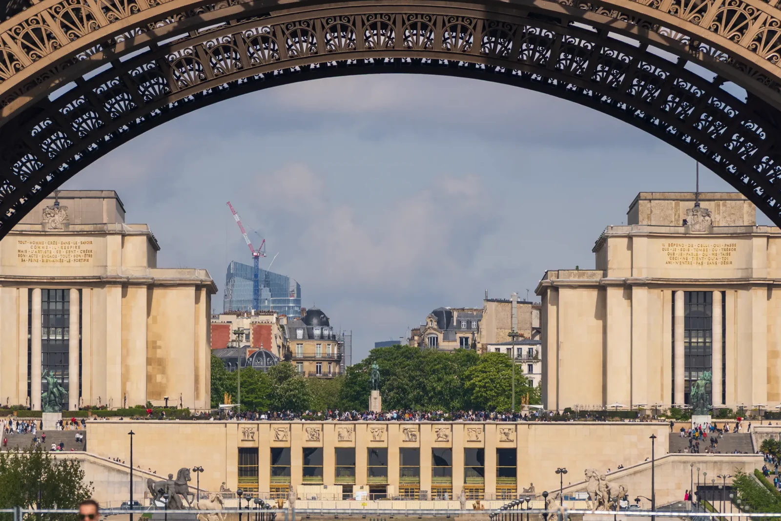 Une arche de la Tour Eiffel encadre le Palais de Chaillot et la ville de Paris.