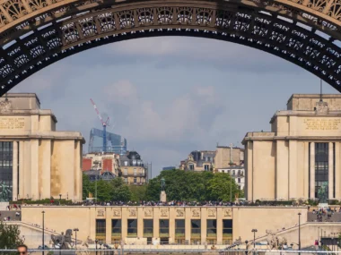Une arche de la Tour Eiffel encadre le Palais de Chaillot et la ville de Paris.
