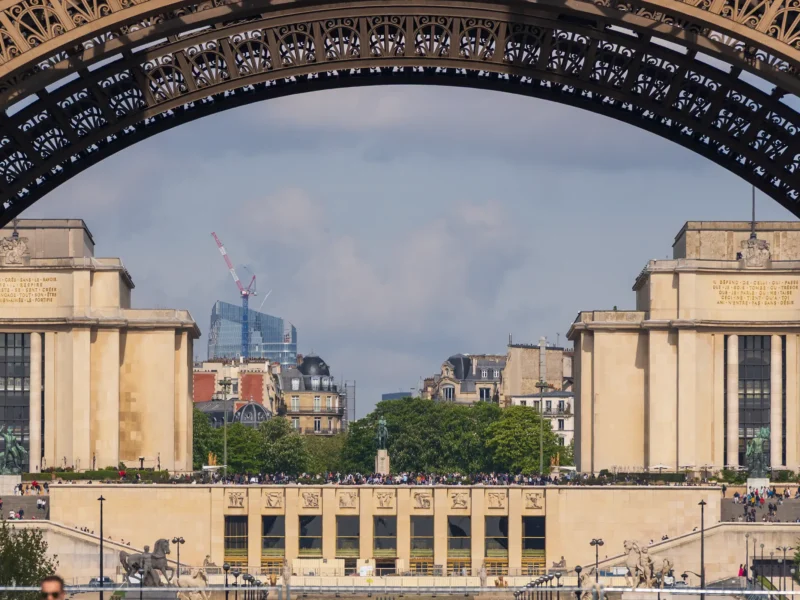 Une arche de la Tour Eiffel encadre le Palais de Chaillot et la ville de Paris.