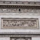 Détail d'une façade en pierre de l'Arc de Triomphe, ornée de frises sculptées.