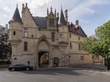 La façade gothique en pierre de la bibliothèque Forney à Paris avec ses deux tourelles.