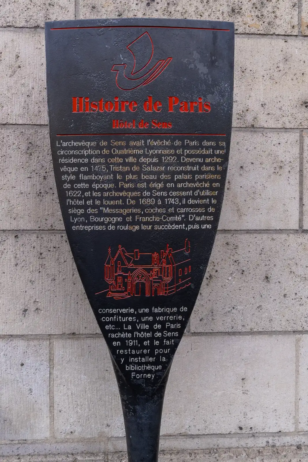 Un panneau noir et rouge d'Histoire de Paris fixé sur un mur en pierre.