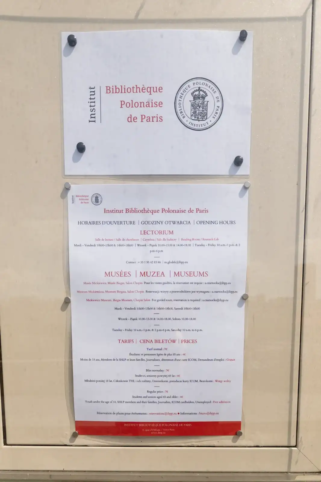 Panneau d information affichant les horaires et tarifs de la Bibliotheque Polonaise de Paris.