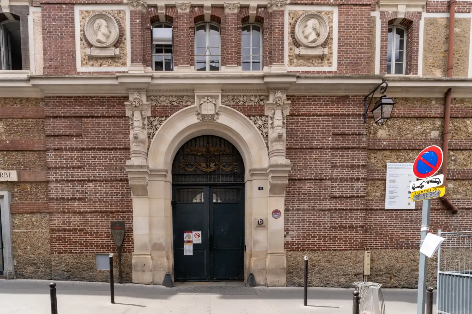 Entrée principale en pierre et briques de la bibliothèque Sainte-Barbe à Paris.
