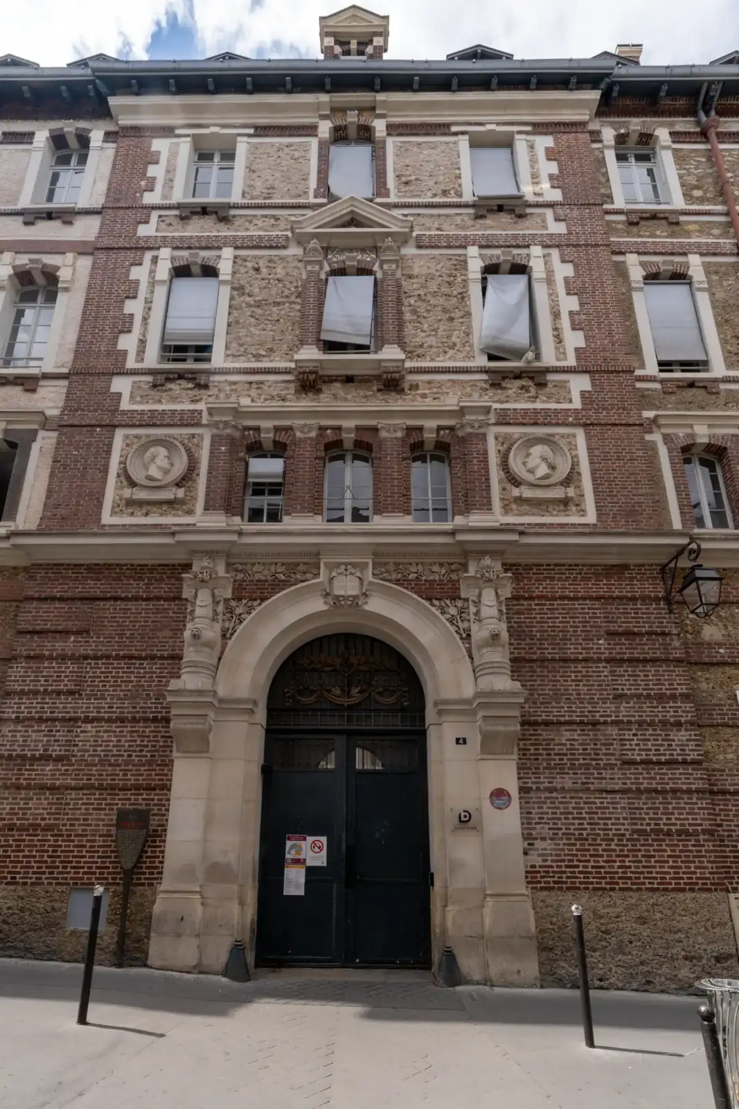 Vue en contre-plongée de la façade ornée en briques et pierre de la bibliothèque Sainte-Barbe.