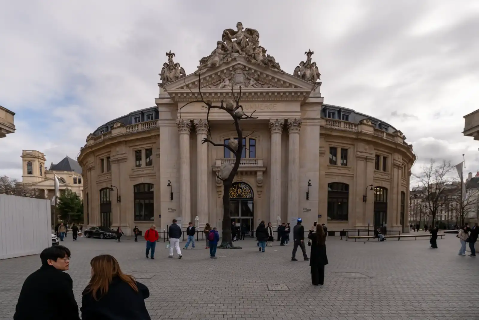 La façade monumentale de la Bourse de Commerce à Paris avec des visiteurs devant.