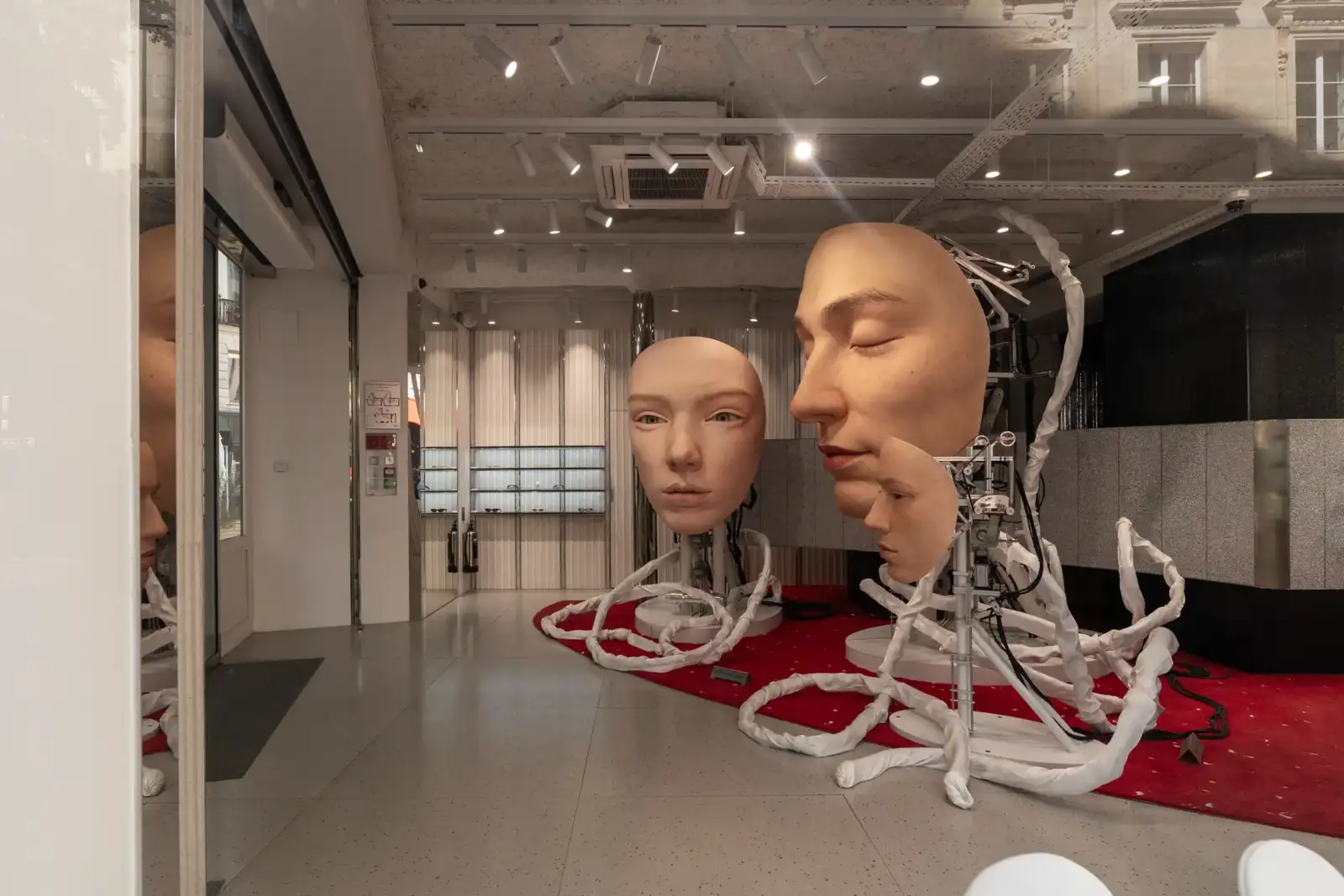Intérieur moderne de la boutique Gentle Monster à Paris avec des sculptures de visages géants.