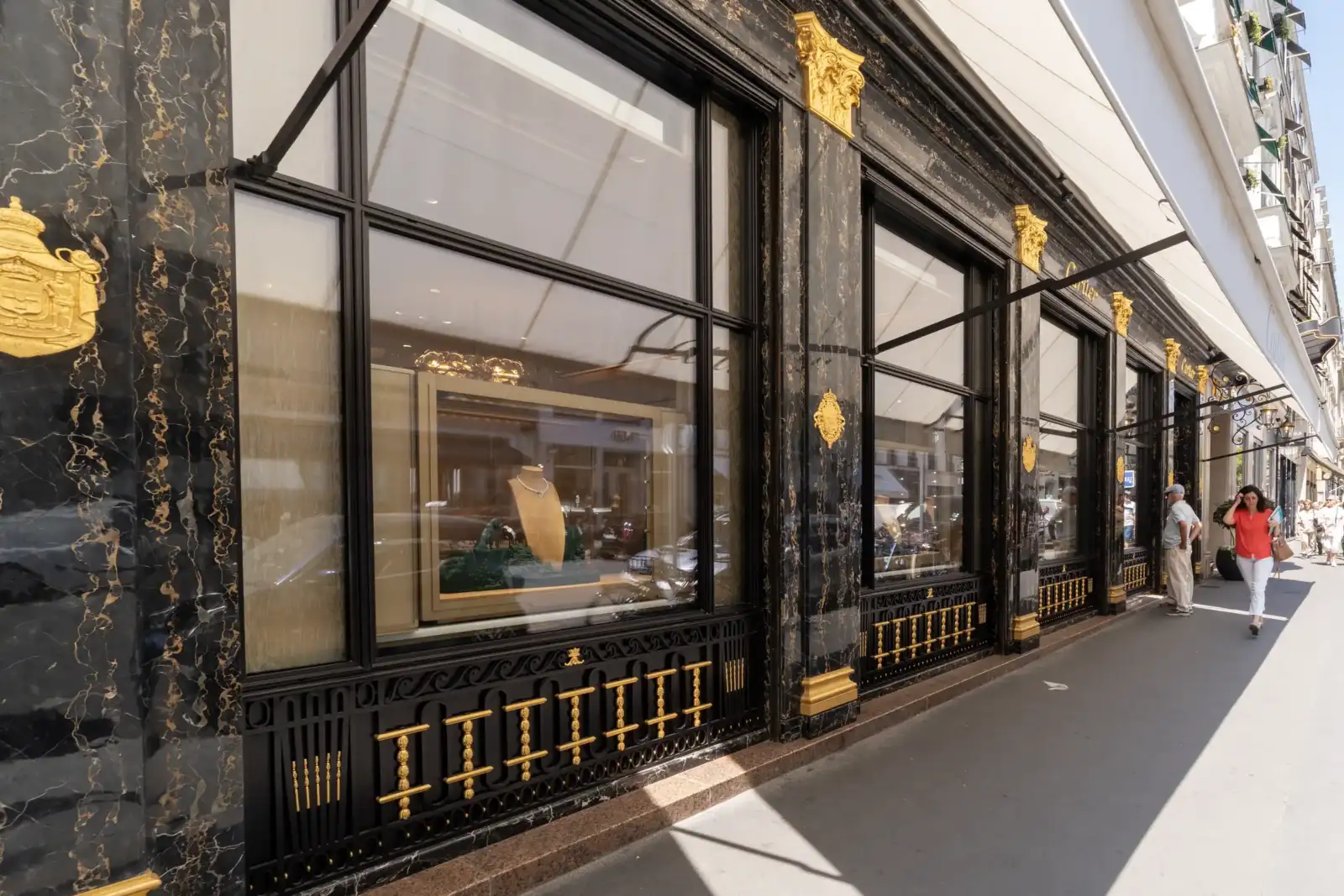 Vitrine élégante en marbre noir et ornements dorés d une boutique parisienne.
