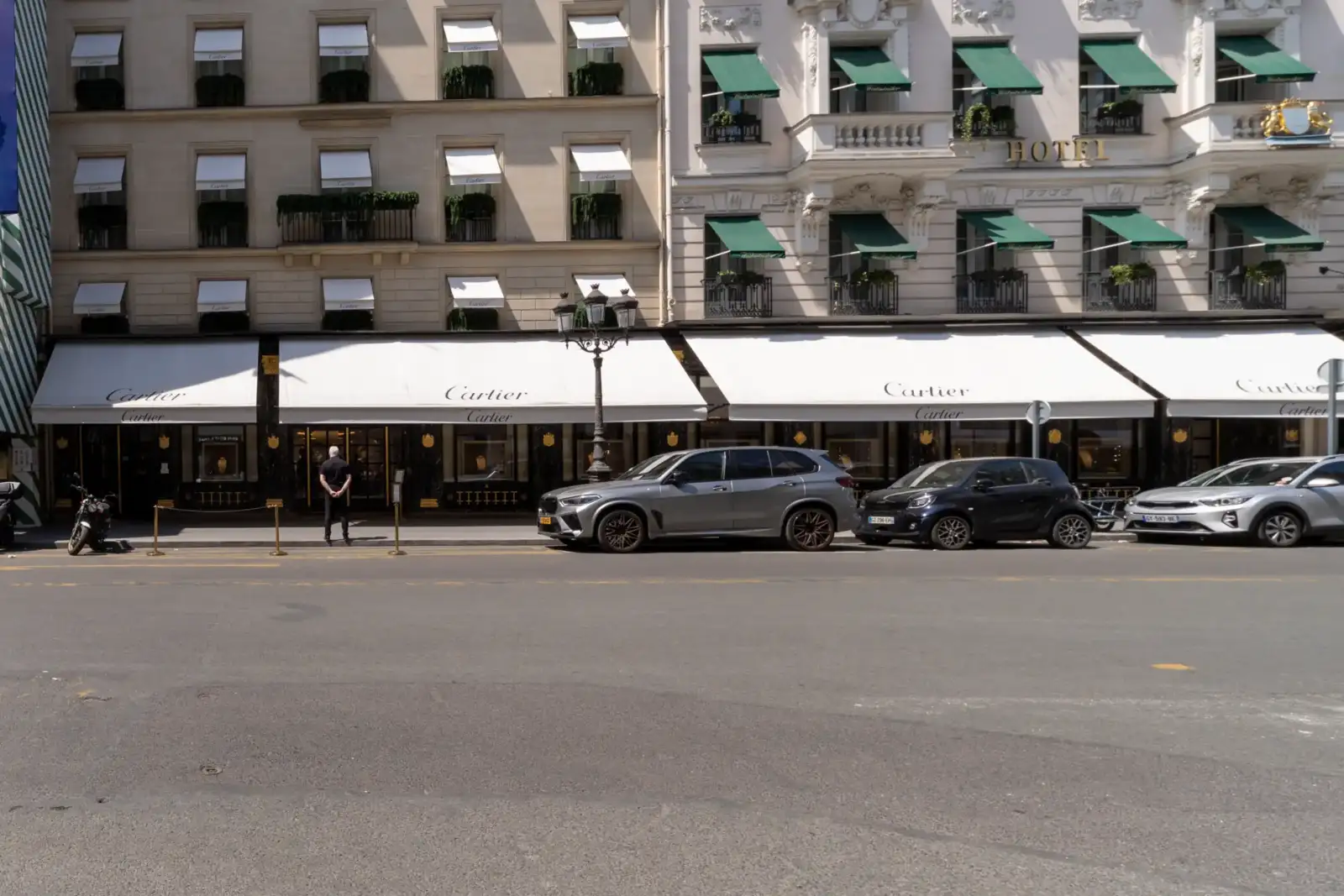 Vue de rue de la luxueuse boutique Cartier à Paris avec des voitures garées.