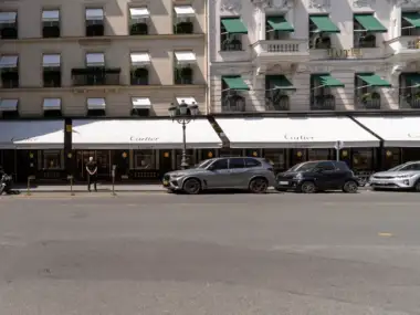 Vue de rue de la luxueuse boutique Cartier à Paris avec des voitures garées.