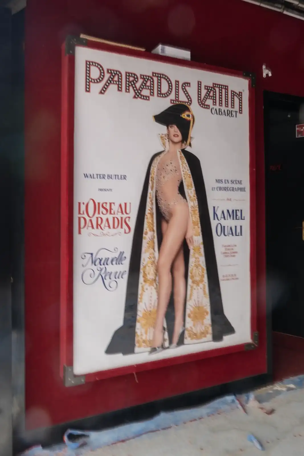 Un grand panneau publicitaire rouge et blanc du cabaret le Paradis Latin à Paris.