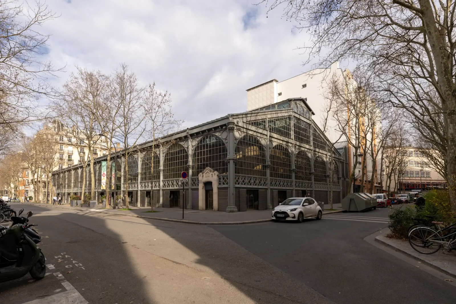La façade métallique du Carreau du Temple se dresse dans une rue de Paris.