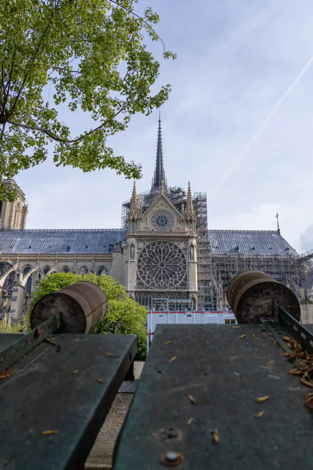 La cathédrale Notre-Dame de Paris en restauration vue derrière des éléments de clôture métalliques.