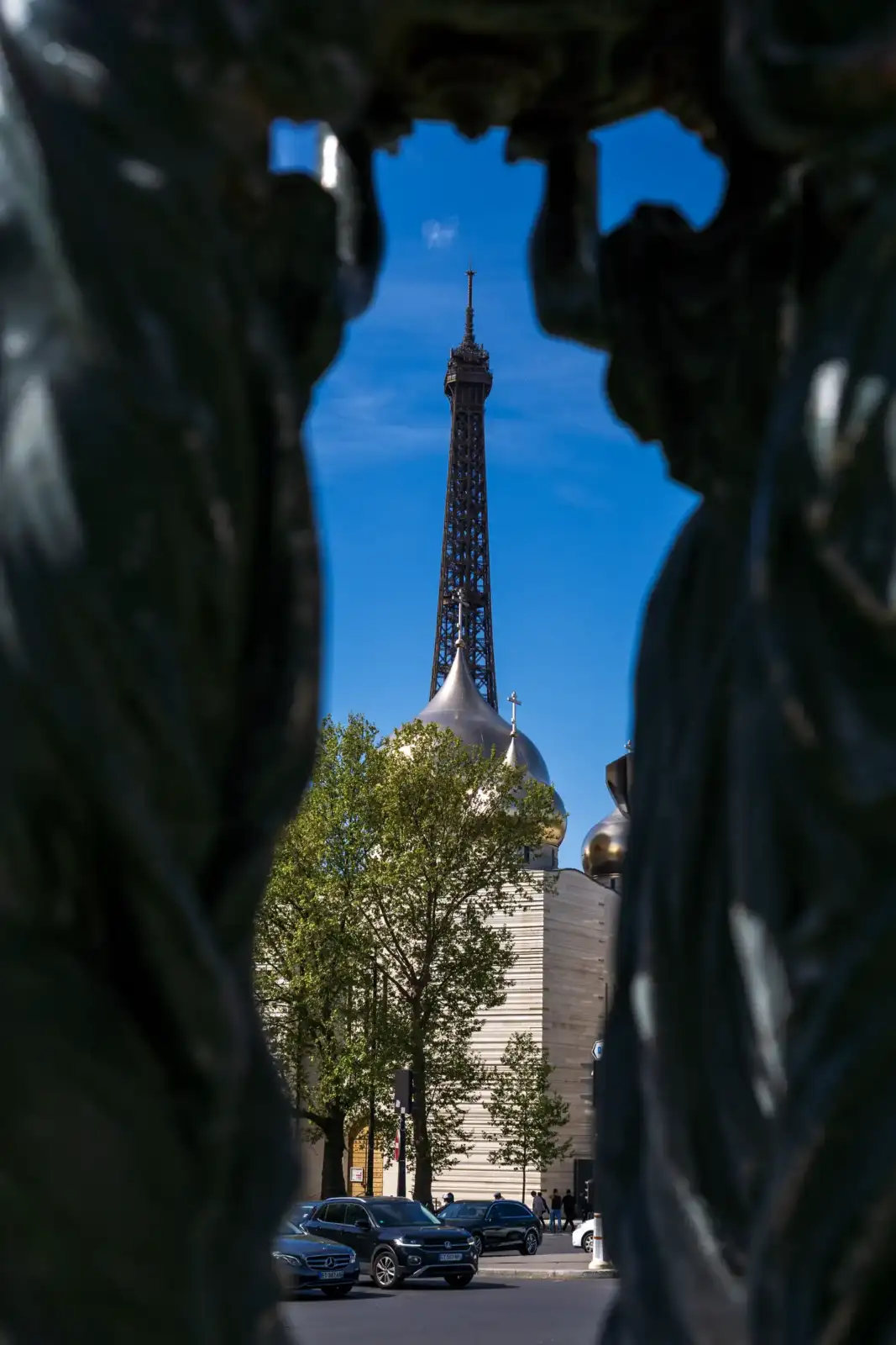 Une vue encadrée montre la cathédrale et la Tour Eiffel sous un ciel bleu.