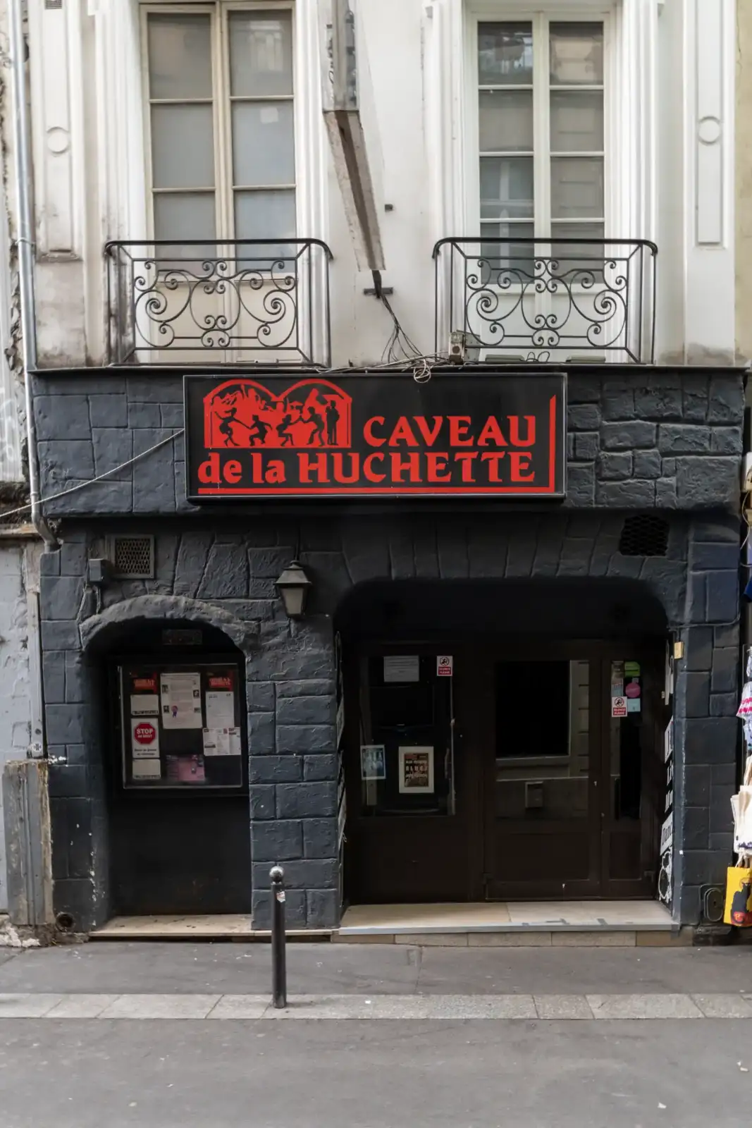 Une façade de club de jazz avec une enseigne rouge et noire lumineuse.