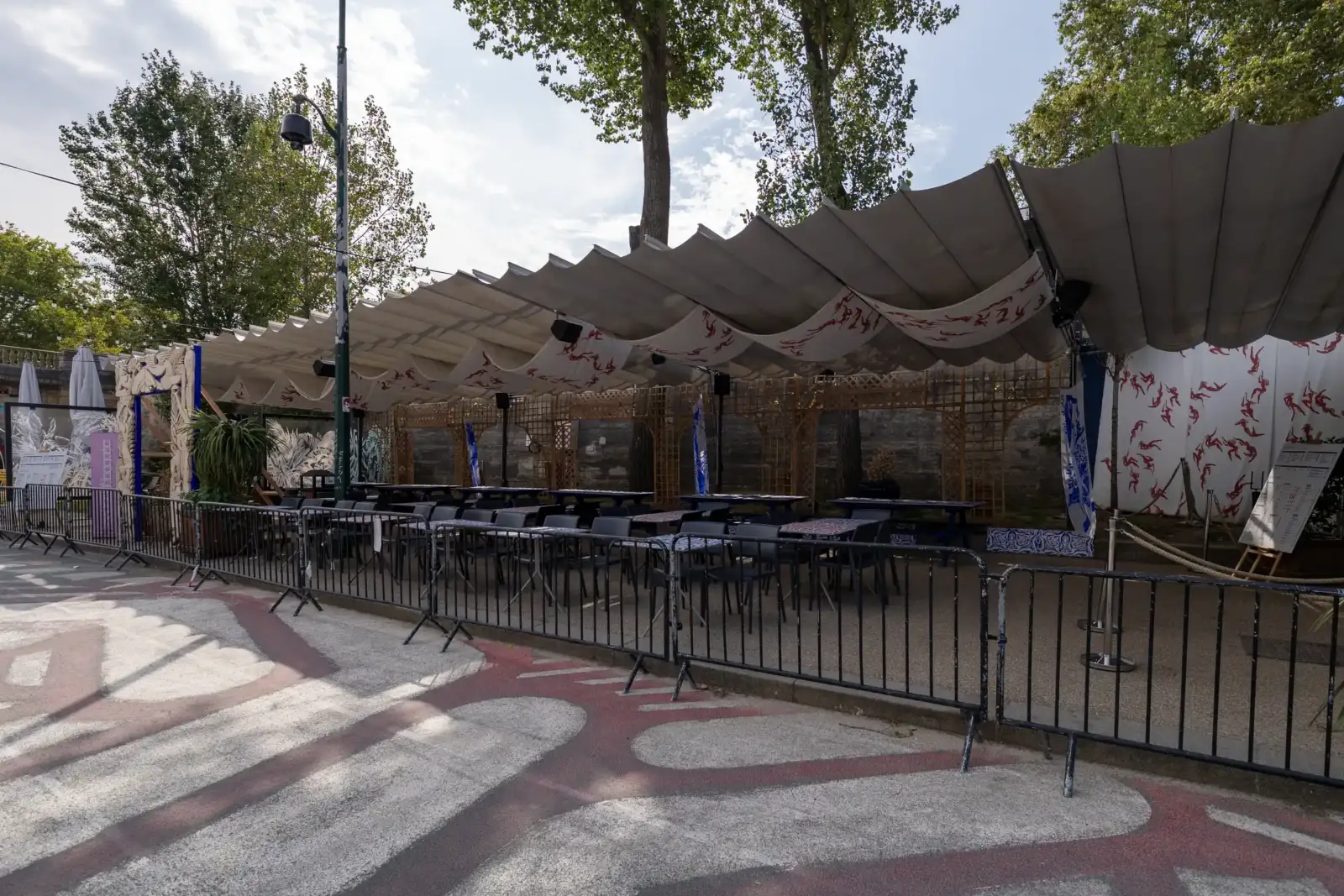 Une terrasse extérieure ombragée est aménagée avec des tables et chaises près de Paris.