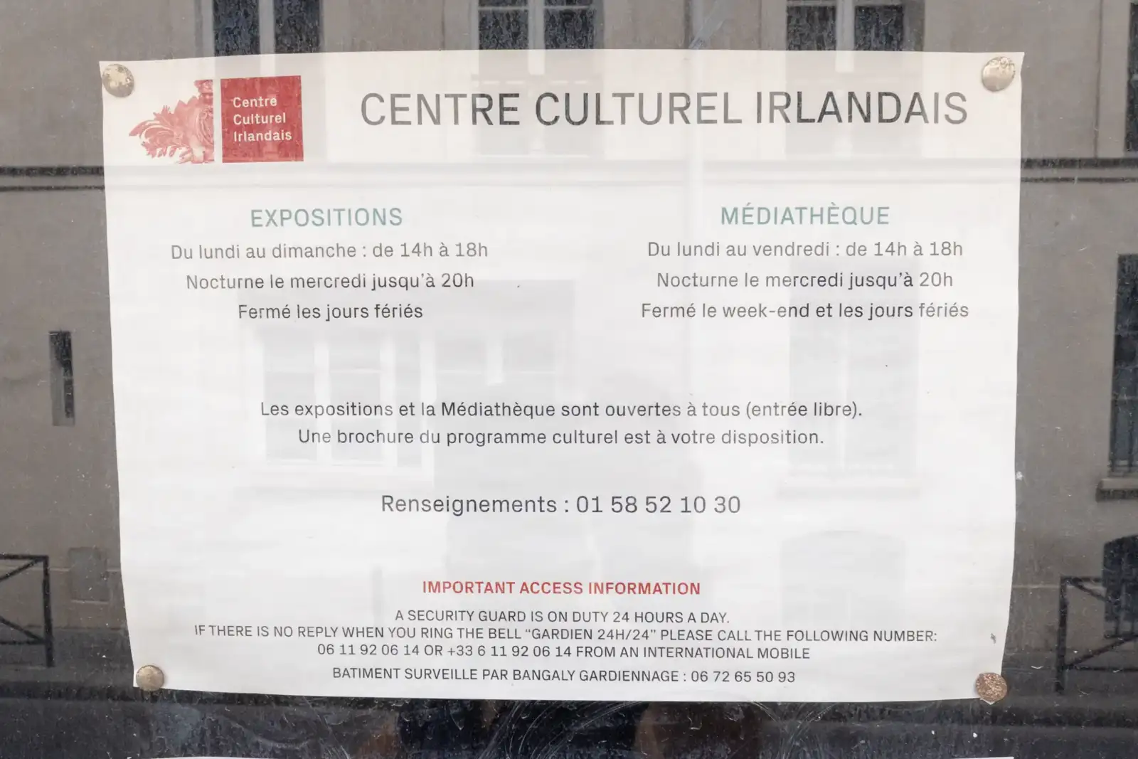Une affiche informative fixée sur une vitre indique les horaires du Centre Culturel Irlandais.