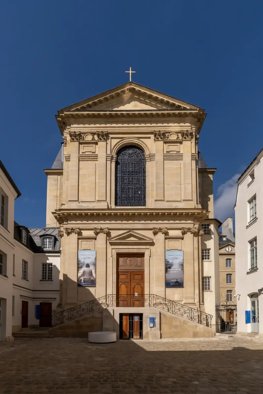 Vue de face de la chapelle parisienne sous un ciel bleu intense et dégagé.