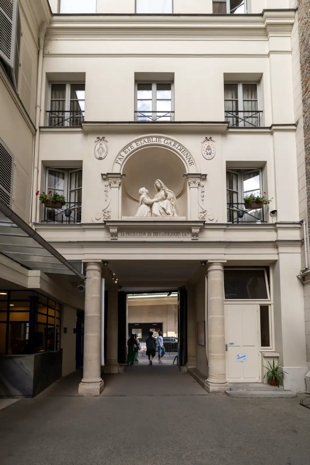 Vue de la cour et de la statue blanche de la chapelle parisienne.