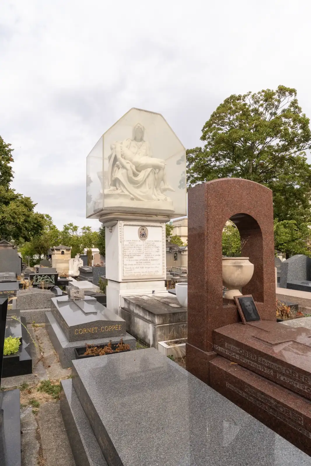 Vue en contre-plongée des tombes du cimetière de Passy, sous un ciel couvert.