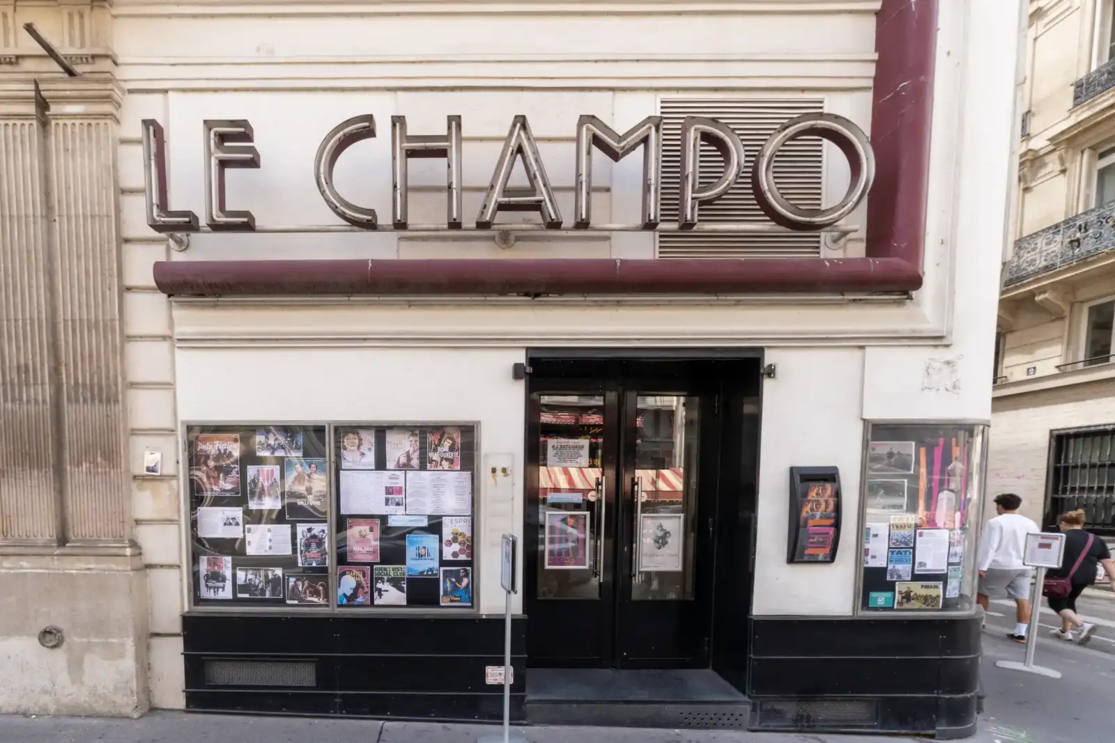 La façade beige du cinéma Le Champo à Paris affiche des enseignes lumineuses distinctives.