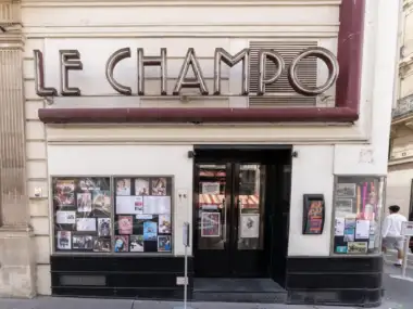 La façade beige du cinéma Le Champo à Paris affiche des enseignes lumineuses distinctives.