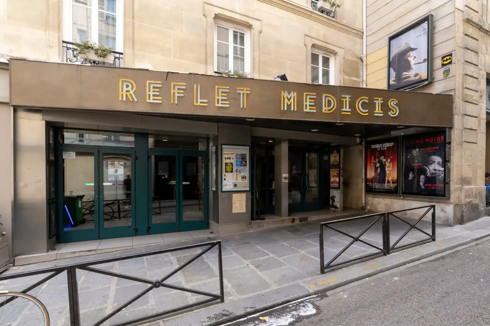 Façade du cinéma Le Reflet Médicis à Paris avec ses portes et affiches de films.