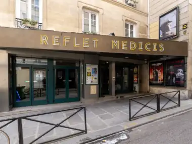 Façade du cinéma Le Reflet Médicis à Paris avec ses portes et affiches de films.