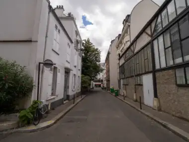 Vue depuis la rue de la cité Falguière avec des bâtiments blancs et des grands ateliers.