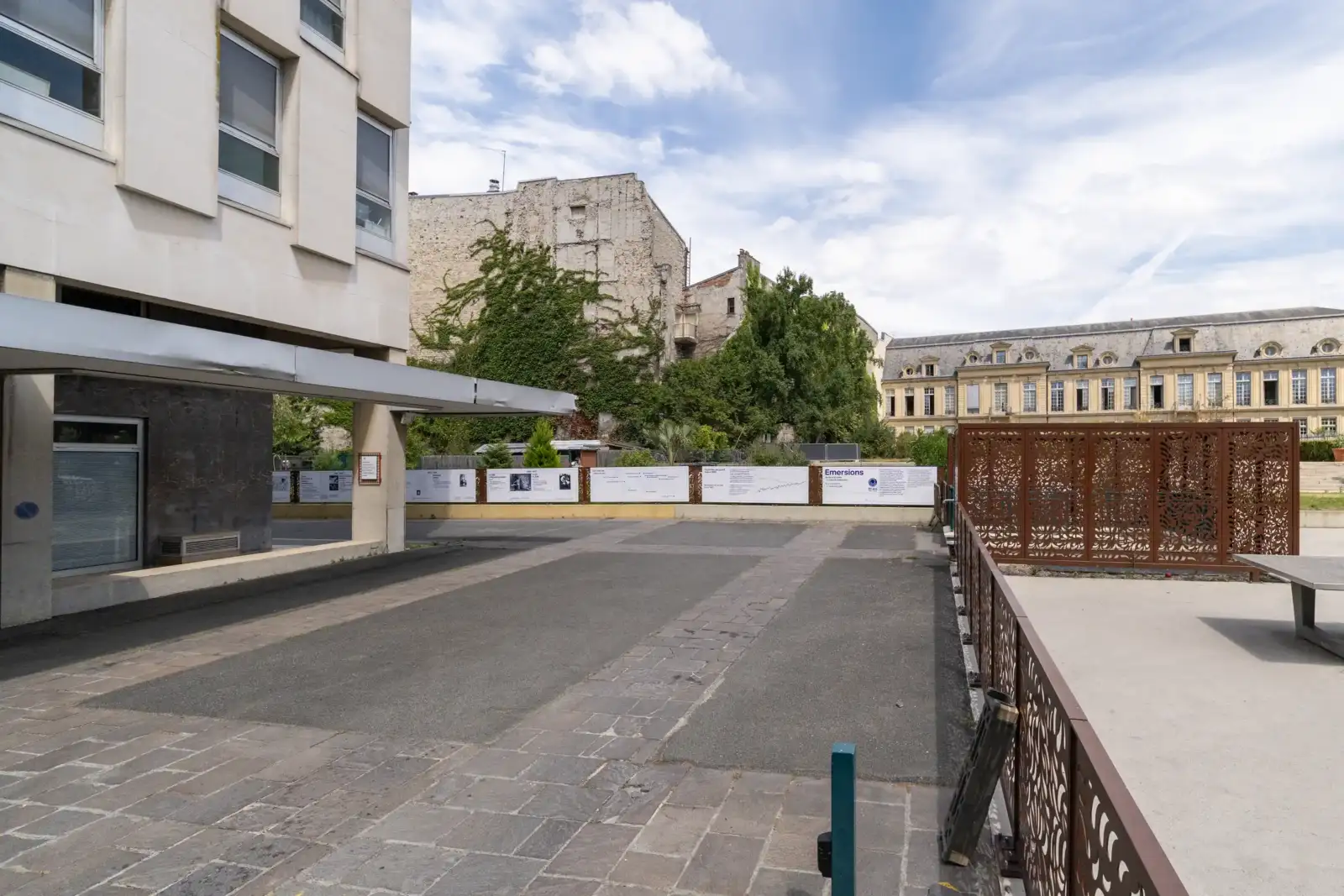 Façade moderne de la Cité internationale des arts à Paris sous un ciel nuageux.