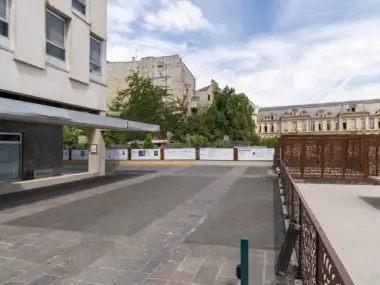 Façade moderne de la Cité internationale des arts à Paris sous un ciel nuageux.