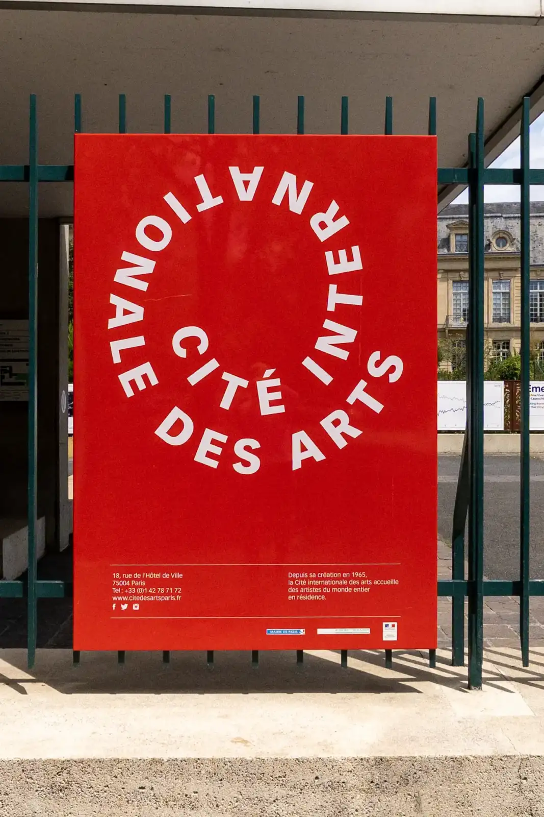 Un panneau rouge vif avec du texte blanc indique la Cité internationale des arts.