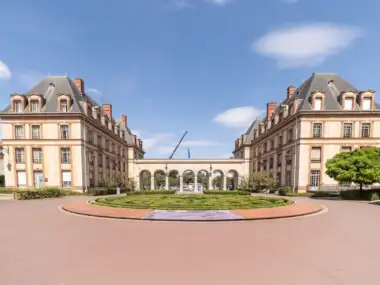 Façade de la Cité internationale universitaire de Paris avec un jardin circulaire devant.