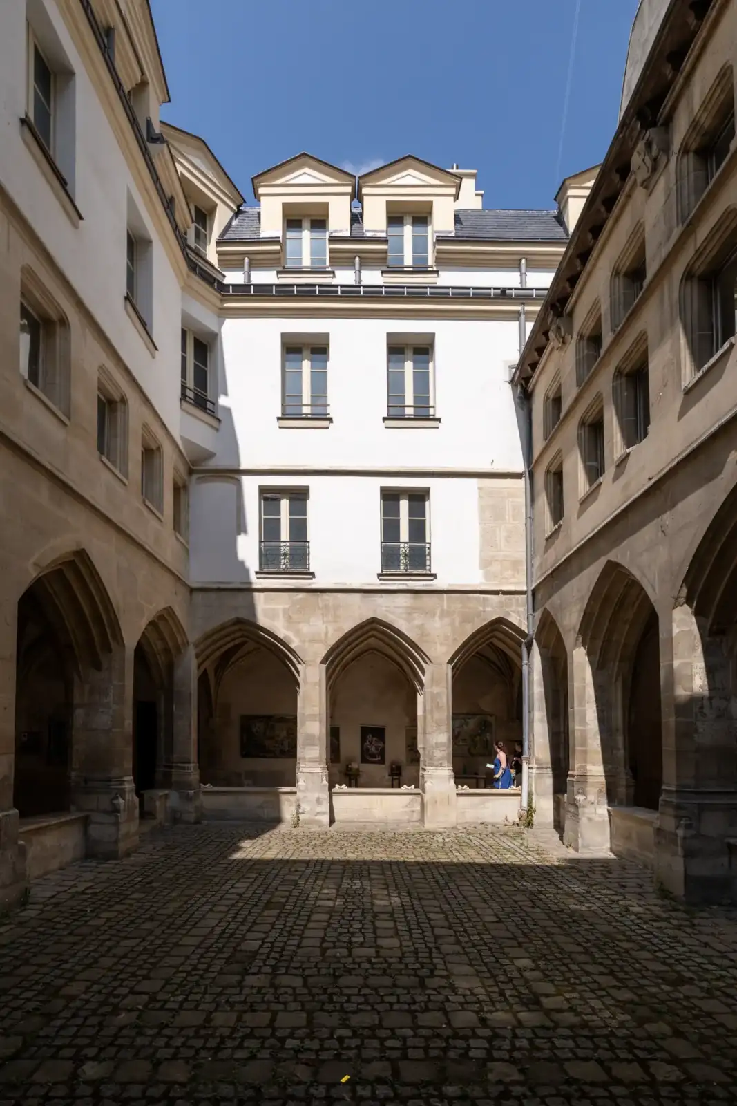 Vue intérieure de la cour pavée du cloître des Billettes à Paris.
