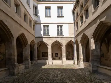 Vue intérieure de la cour pavée du cloître des Billettes à Paris.