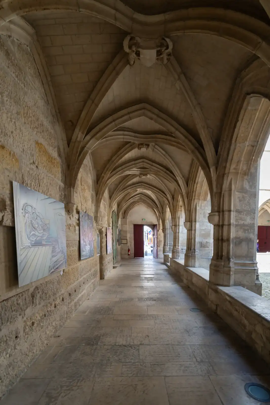 Intérieur voûté du cloître des Billettes à Paris accueillant une exposition artistique.