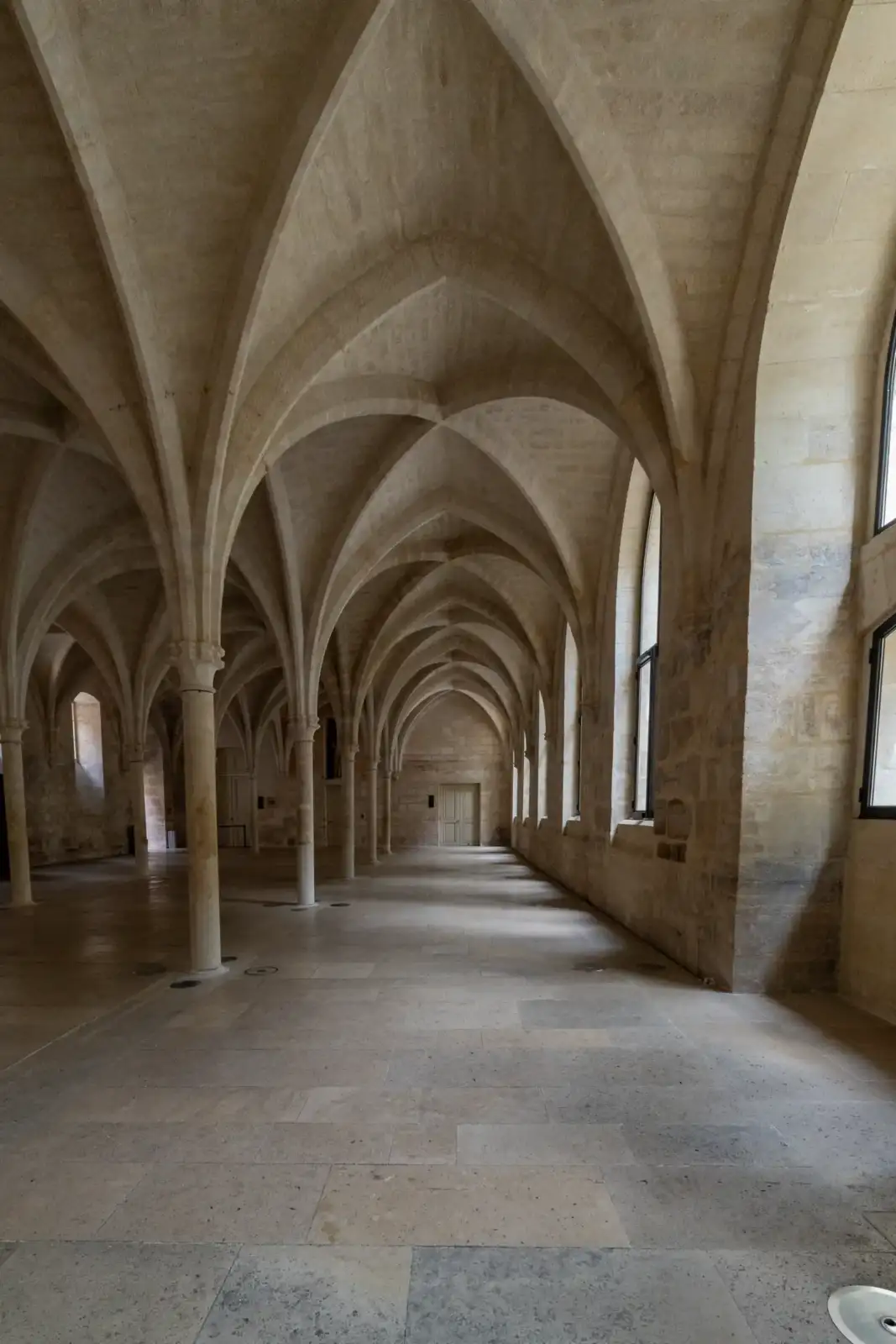 Vue intérieure des voûtes gothiques et des colonnes de pierre du collège des Bernardins.