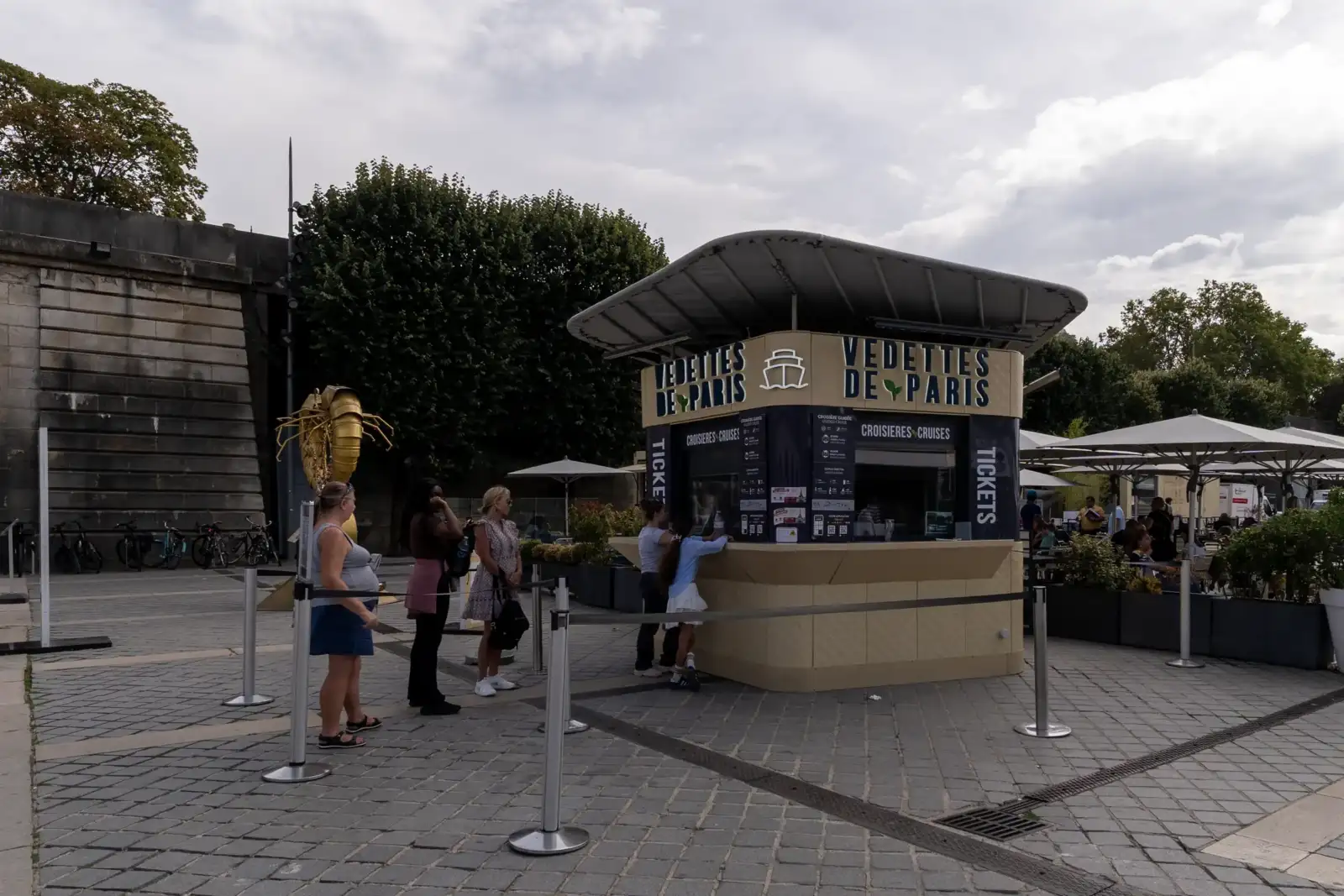 Des personnes font la queue devant un guichet de croisières à Paris.