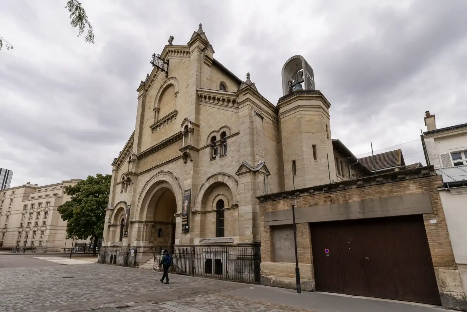 Vue extérieure de l'église Notre-Dame-du-Travail à Paris sous un ciel nuageux.