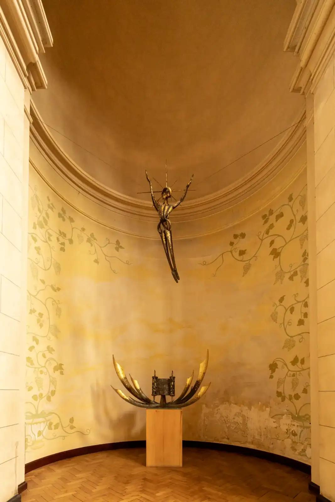 Vue intérieure de l église Notre-Dame-du-Travail à Paris, montrant une sculpture dorée sous une voûte.
