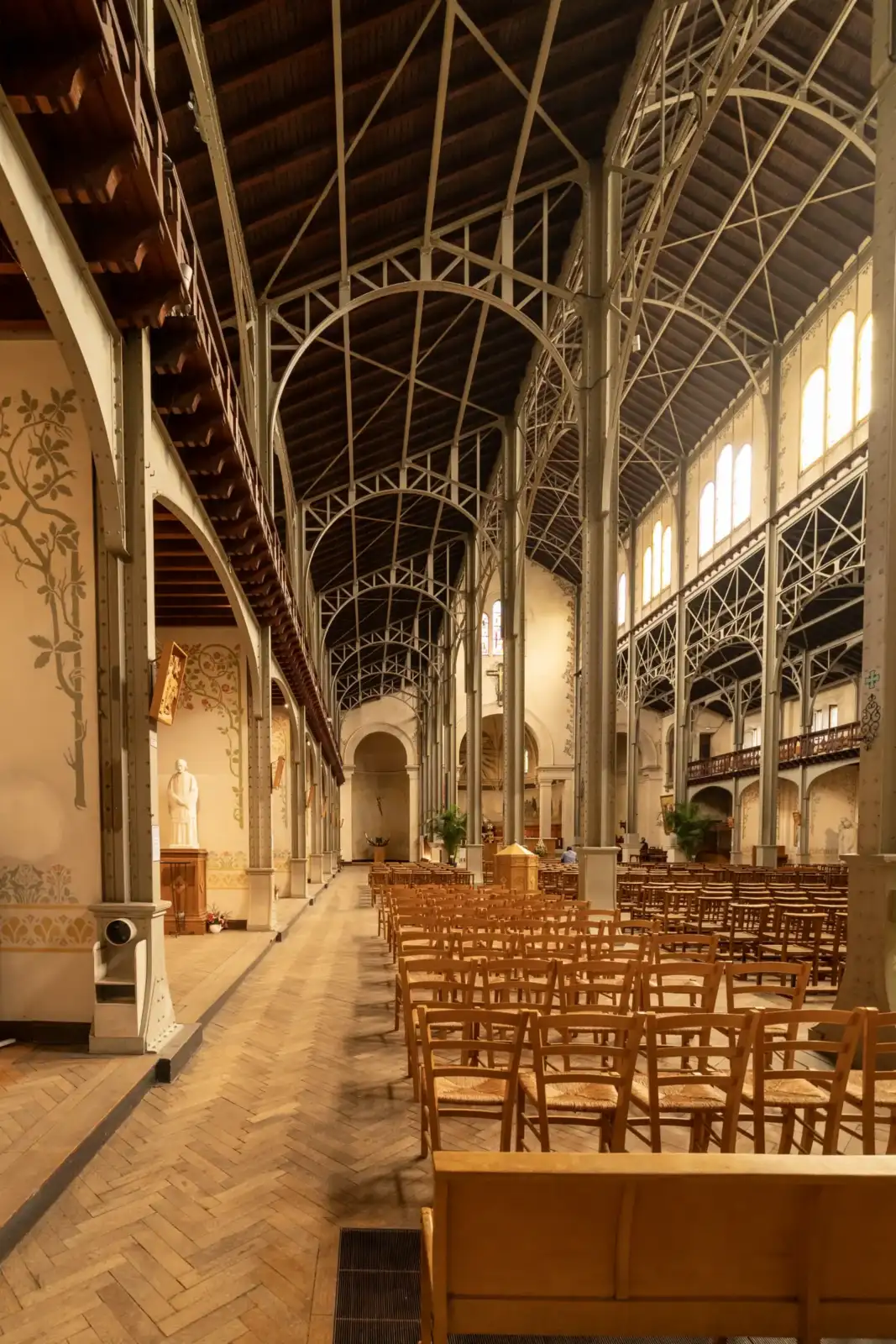 Vue intérieure de l'église Notre-Dame-du-Travail avec sa spectaculaire charpente métallique apparente.