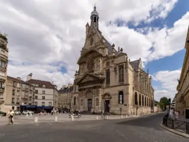 Façade sculptée de l'église Saint-Étienne-du-Mont à Paris, sous un ciel nuageux.