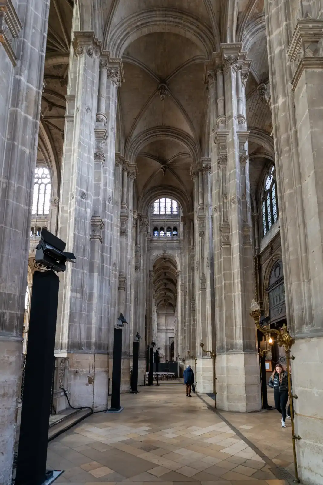 Vue intérieure majestueuse de l'église Saint-Eustache avec ses hautes colonnes et voûtes en pierre.