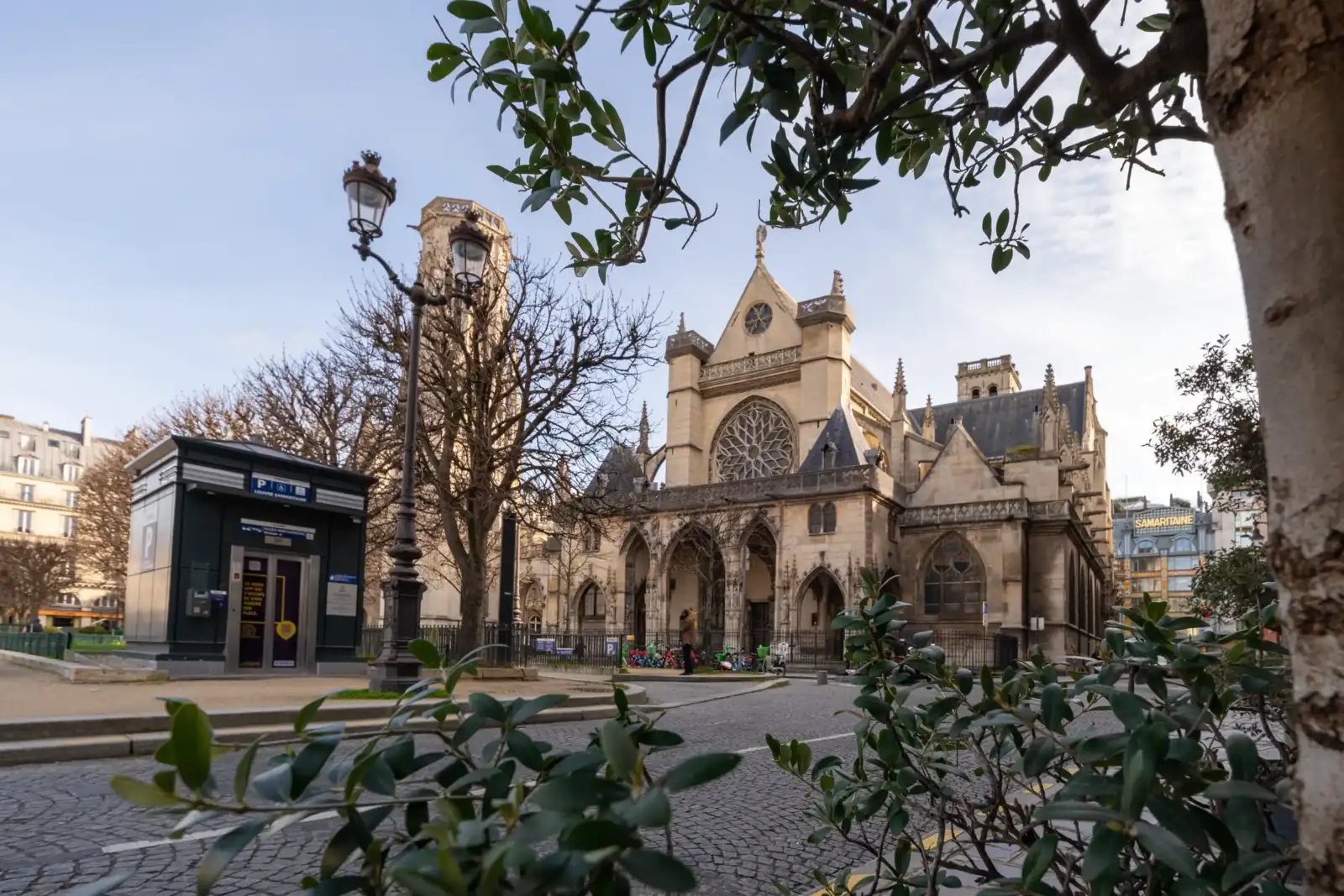 La façade gothique de l'église Saint-Germain-l'Auxerrois se dresse majestueusement sur une place pavée parisienne.