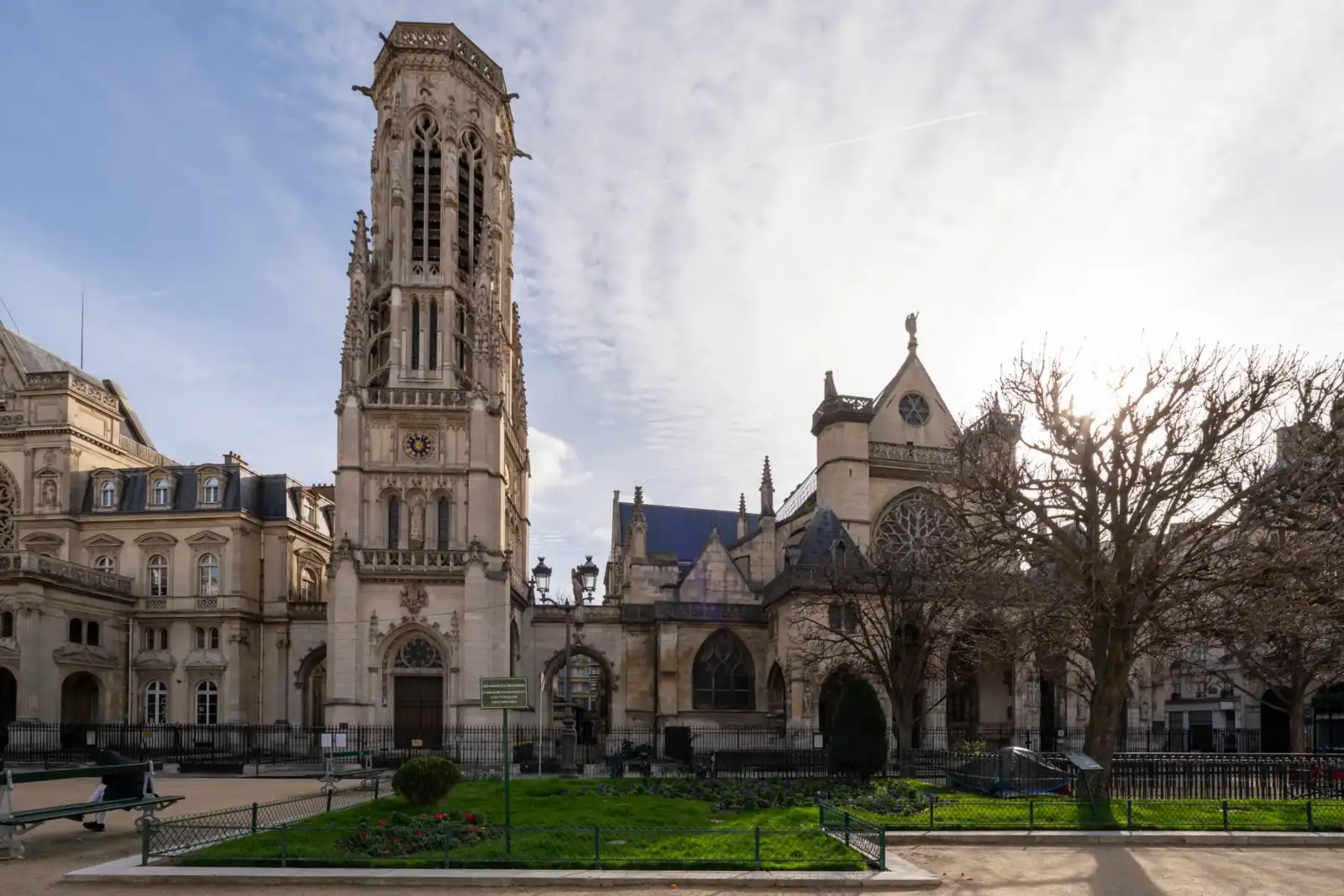 La façade gothique de l'église Saint-Germain-l'Auxerrois se dresse majestueusement sous un ciel ensoleillé.