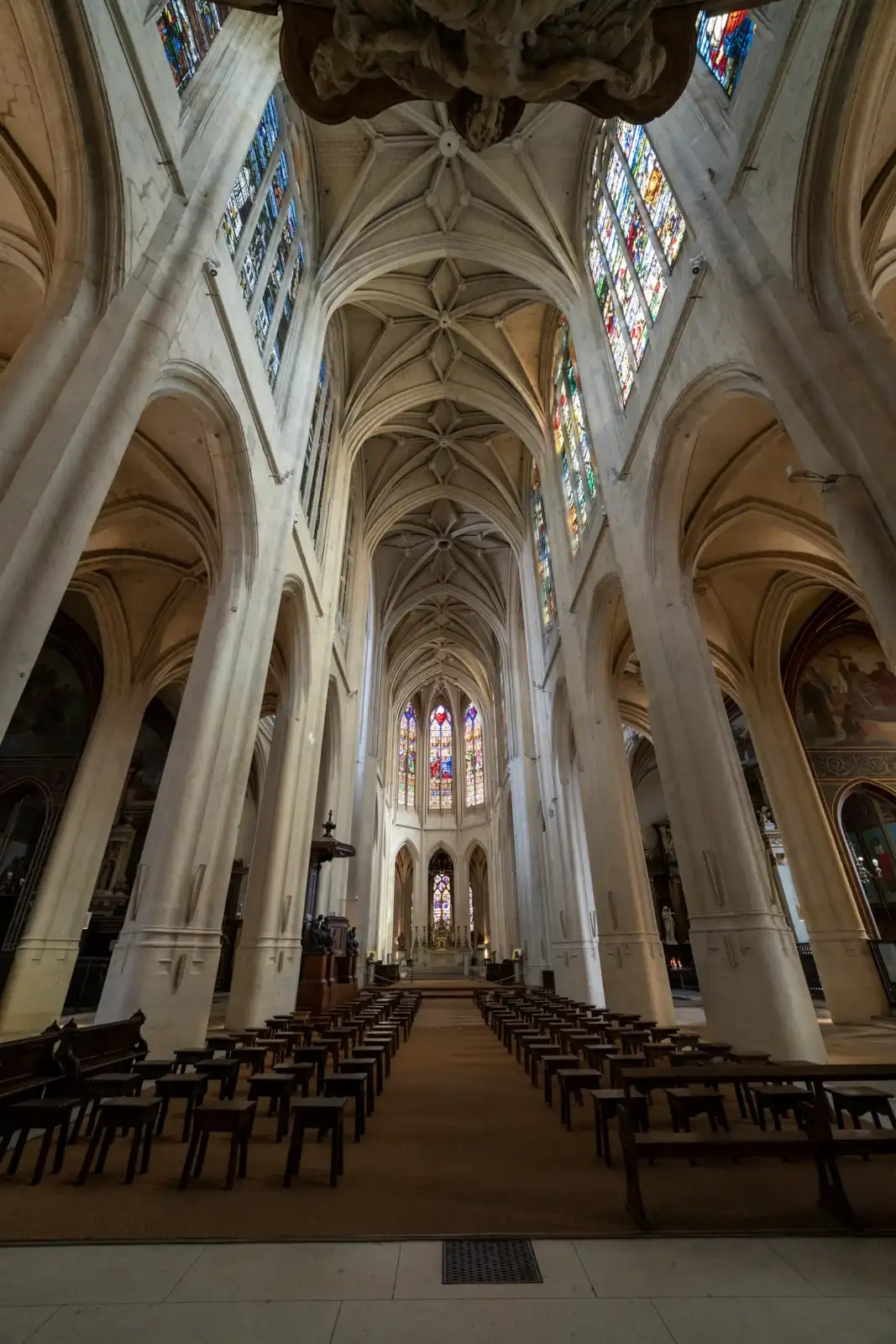 Vue en contre-plongée de la nef gothique et des vitraux de l'église Saint-Gervais-Saint-Protais à Paris.