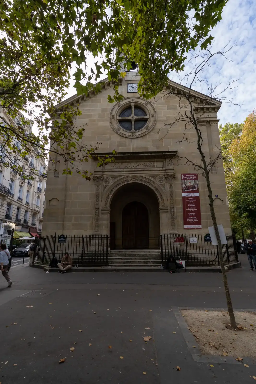 Vue de face de l église Saint Honoré d Eylau encadrée par des arbres parisiens.