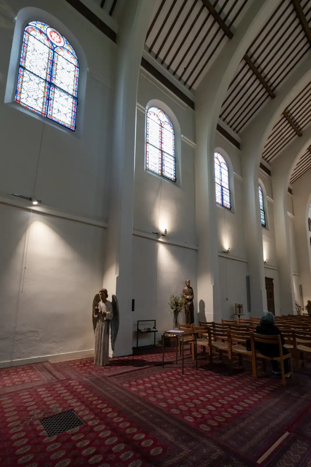 Vue intérieure de l'église Saint-Honoré-d'Eylau à Paris avec des vitraux et des statues.