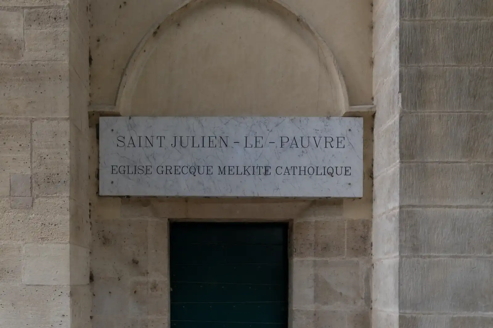 Une plaque en marbre blanc indique le nom de l'église parisienne Saint Julien le Pauvre.