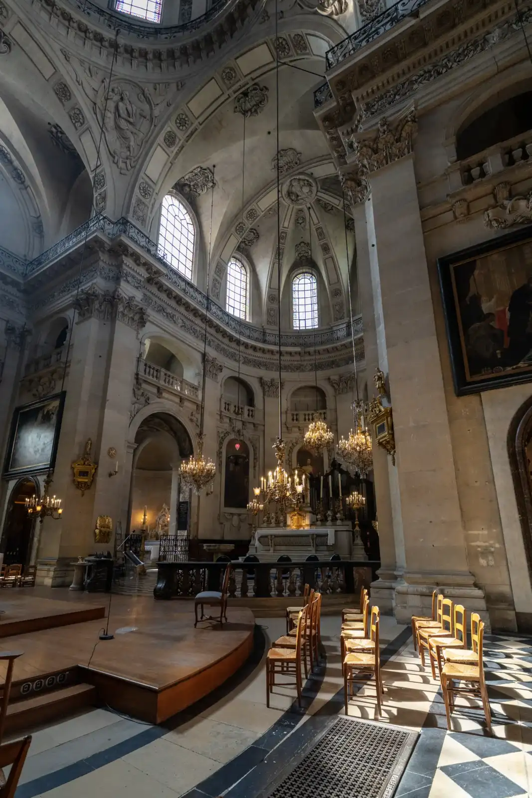 Vue intérieure lumineuse de l'église Saint-Paul-Saint-Louis avec des colonnes baroques et des lustres suspendus.